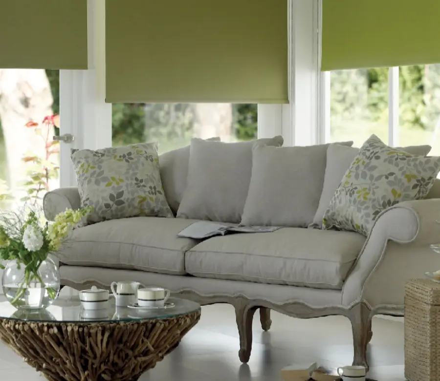 Woman pulling down fabric roller blinds in a modern Dubai living room